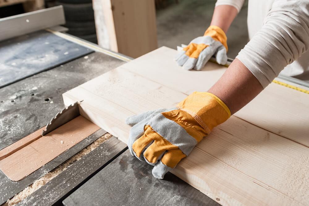 Personne qui découpe une planche de bois